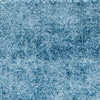 Blue fabric texture with dense pile and subtle mottling, displaying variations in tone and a soft, irregular fiber surface.